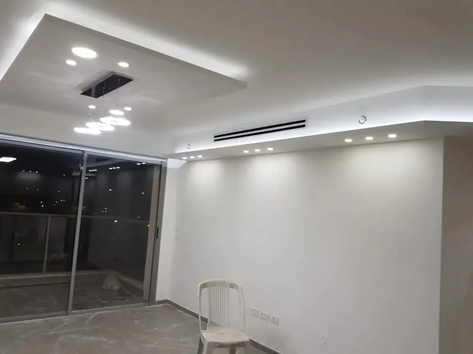 סלון בפרויקט בגוש דן עם פתח מיזוג לינארי ותקרת גבס מוארת
