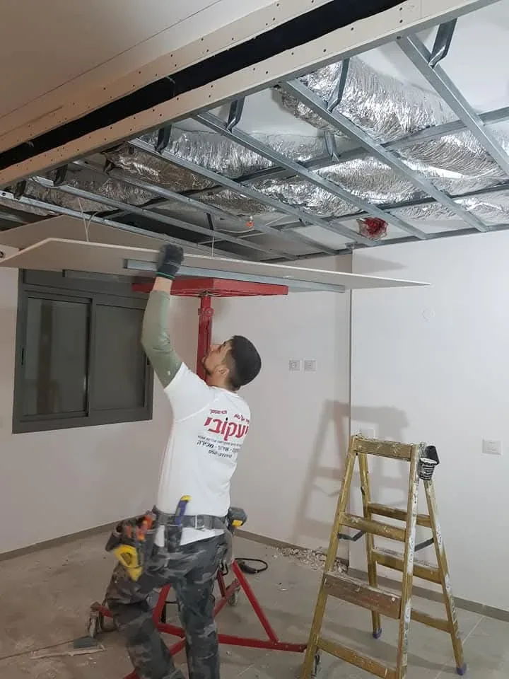 אוהד יעקובי עובד על הנמכת גבס ותשתיות מיזוג בתקרה
