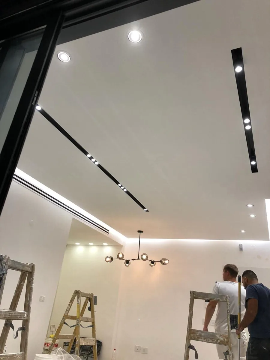 סלון עם פתחי מיזוג לינאריים ותאורה משולבת בגבס